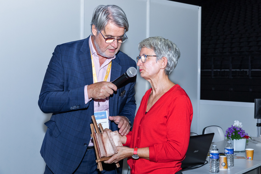 Kristel Leclercq, artiste choisie par la Club des CSE Citoyens, explique comment elle a réalisé ce livre en céramique, livre qui sera offert à Thierry Jeantet avec le traditionnel trophée en baccarat - Photo : Jacques Martin -