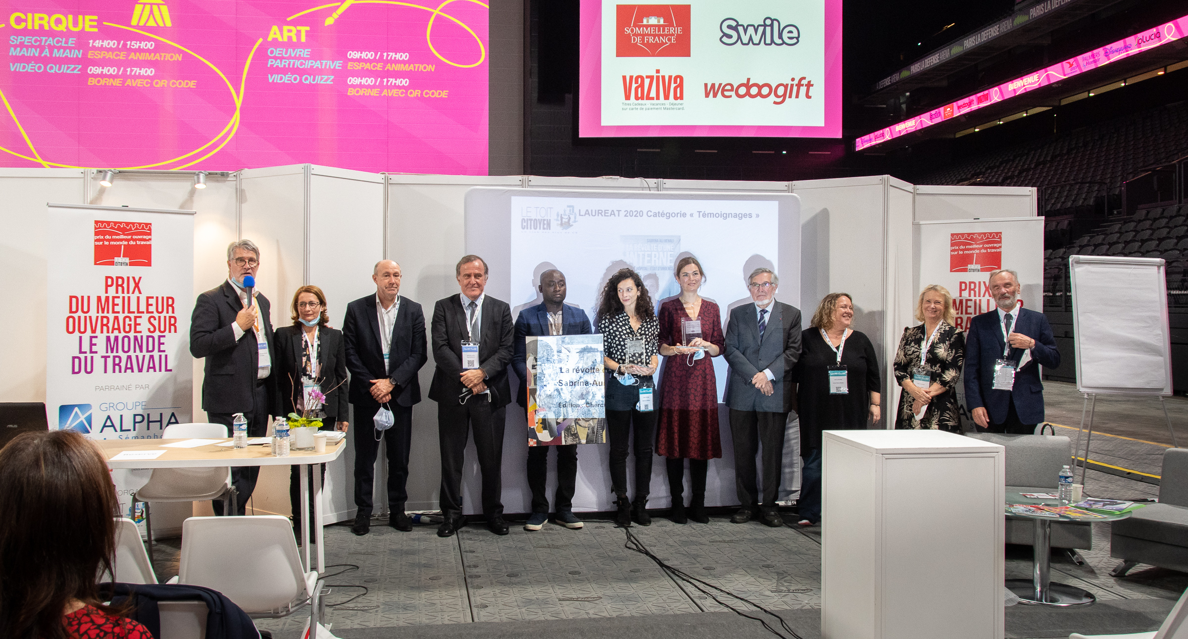 Photo de famille pour une remise de prix unique ! De gauche à droite : Patrick Gobert, Sandrine Babu (libraire), François Desriaux (rédacteur en chef de Santé et Travail), Pierre Ferracci, Jean-Baptiste Kandod'J (artiste du prix), Sabrina Ali Benali, Marie-Anne Valfort, Jean Auroux, Anne Guillemard (assistante au Toit Citoyen lors de la création du Prix), Marie Pezé (jurée et marraine du Club) et Alain Supiot - Photo : Catherine Cros -