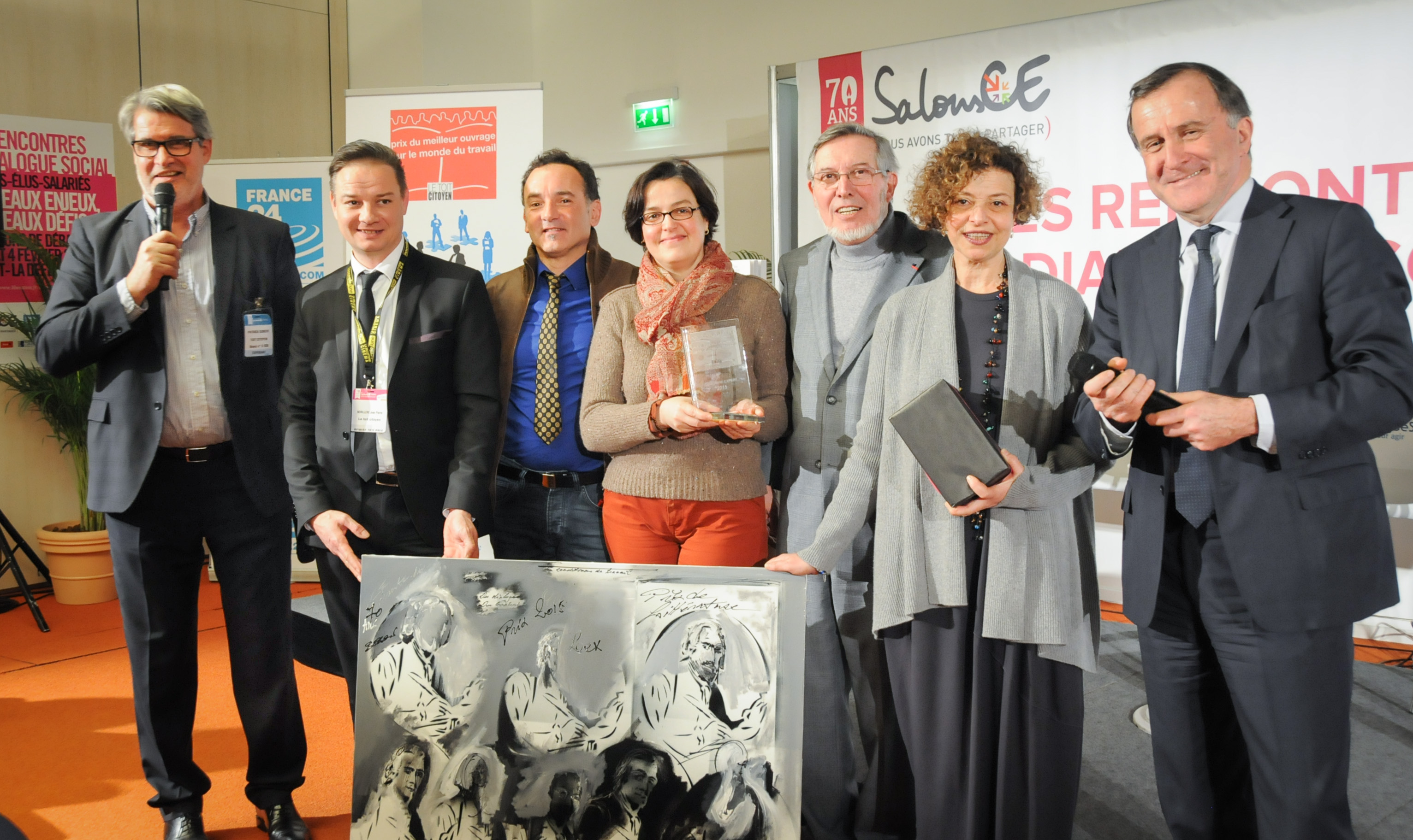 Jean Auroux entoure Rachel Silvera, félicitée chaleureusement par Pierre Ferracci et son éditrice Elisabeth Lau qui tient le trophée. Près d'elle, Eric Besson, le peintre qui avait été choisi pour cette édition et près de Patrick Gobert au micro, Jean-Pierre Lorillère, directeur de la caisse du Crédit Mutuel de la Défense, nouveau partenaire du Prix.... Photo : Catherine Cros Jean Auroux entoure Rachel Silvera, félicitée chaleureusement par Pierre Ferracci et son éditrice Elisabeth Lau qui tient le trophée. Près d'elle, Eric Besson, le peintre qui avait été choisi pour cette édition et près de Patrick Gobert au micro, Jean-Pierre Lorillère, directeur de la caisse du Crédit Mutuel de la Défense, nouveau partenaire du Prix.... Photo : Catherine Cros